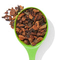 Organic Orange Spice loose leaf tea in a green spoon with spices